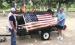Jim Foster and Jeff Nicholas display an American flag before placing it in the fire for disposal.
