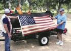 Jim Foster and Jeff Nicholas display an American flag before placing it in the fire for disposal.